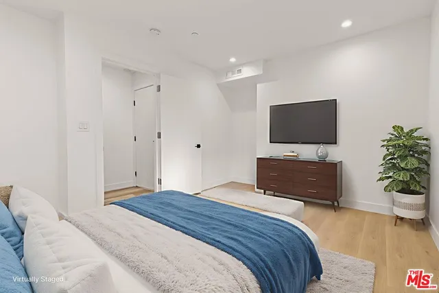 a bedroom with a bed and a flat screen tv