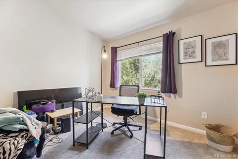 a view of a workspace with furniture and a window