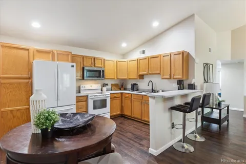 a kitchen with a refrigerator and a stove top oven