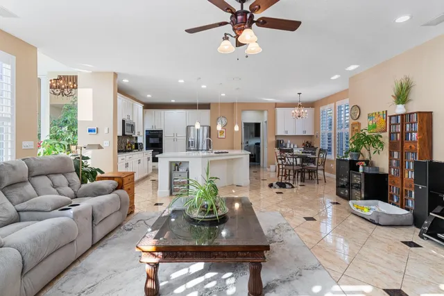 a living room with furniture a bookshelf and a chandelier