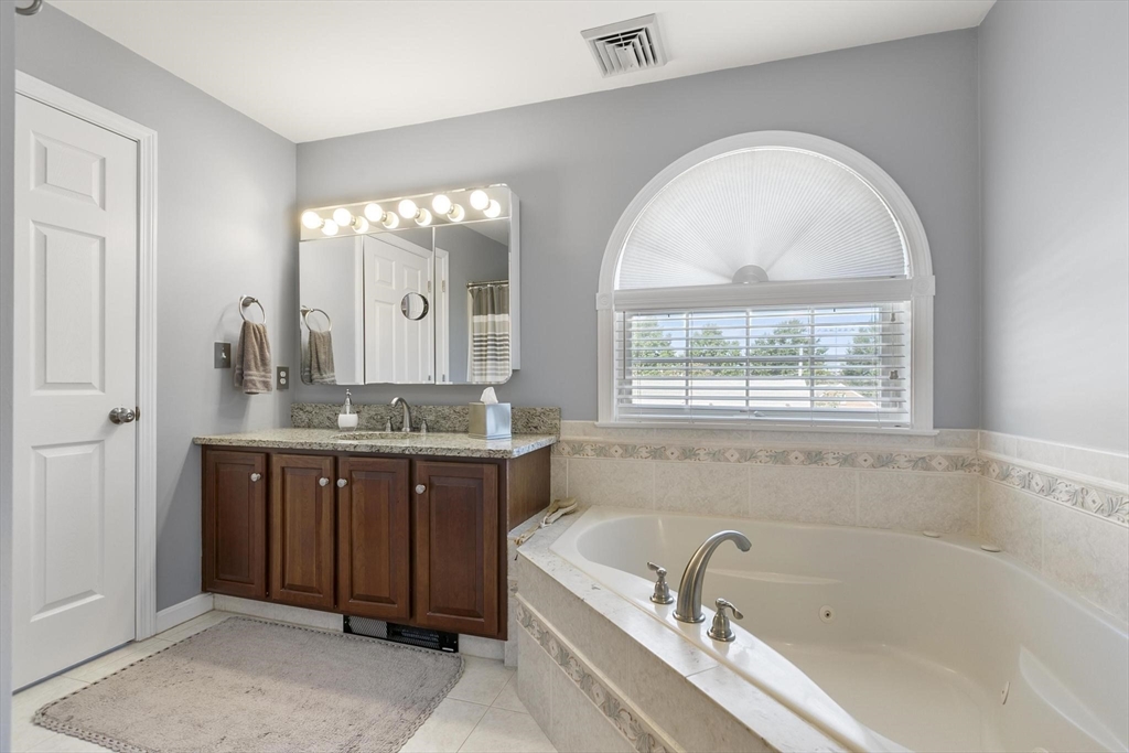 16 Windsor Street Everett, MA 02149 - Photo 16 of 40 a spacious bathroom with a tub a double vanity sink a window and a mirror