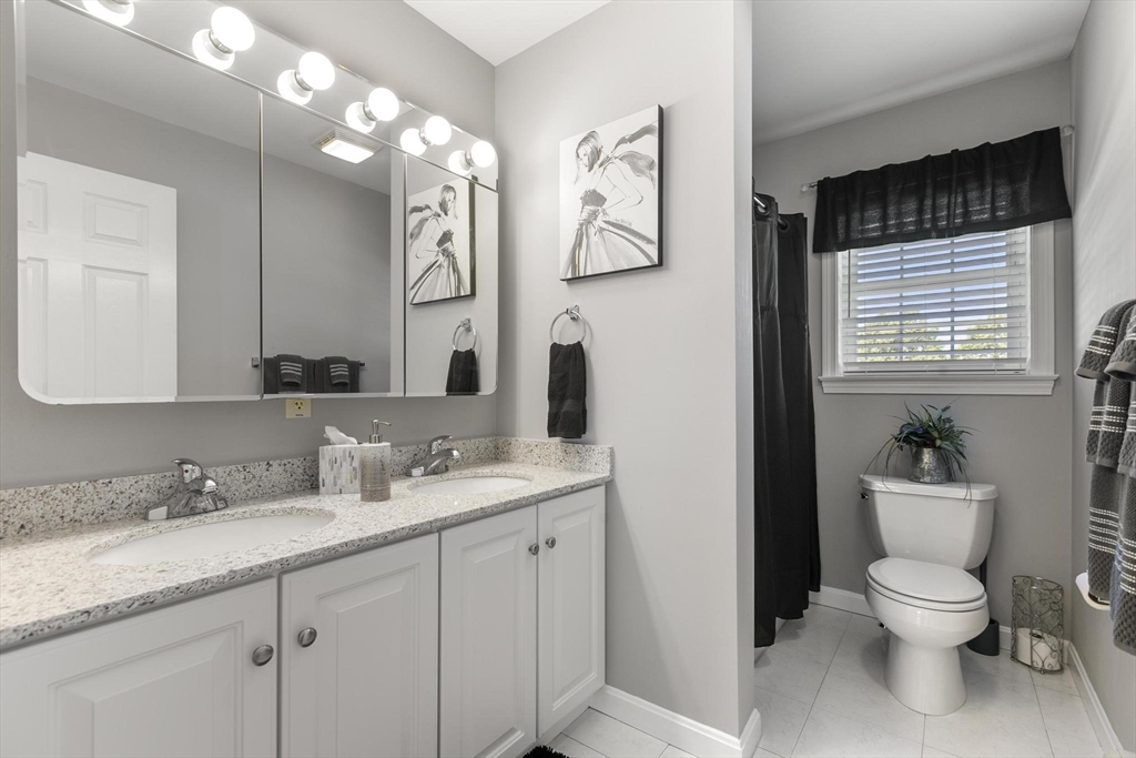 16 Windsor Street Everett, MA 02149 - Photo 20 of 40 a bathroom with a granite countertop toilet sink and mirror