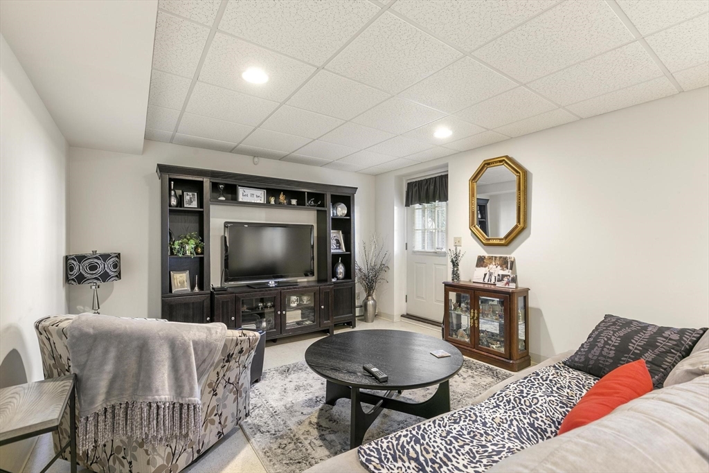 16 Windsor Street Everett, MA 02149 - Photo 26 of 40 a living room with furniture a mirror and a flat screen tv