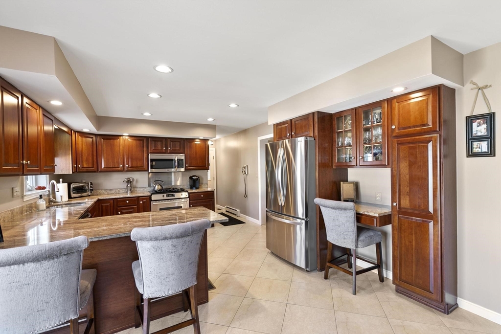 16 Windsor Street Everett, MA 02149 - Photo 10 of 40 a kitchen with stainless steel appliances kitchen island granite countertop a refrigerator oven a sink a dining table and chairs with the view of kitchen