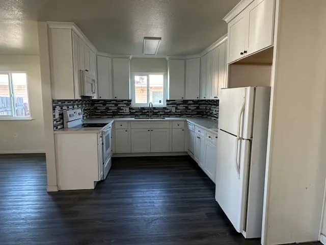 a kitchen with granite countertop a refrigerator and a stove