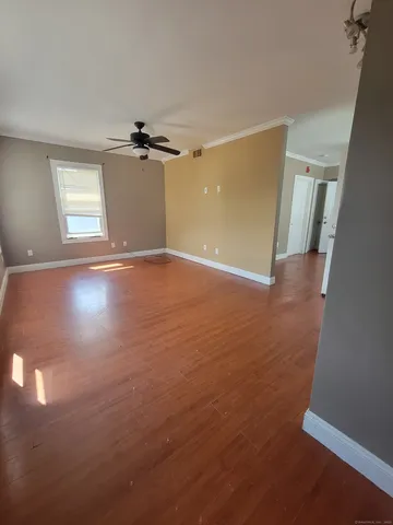 an empty room with windows and fan