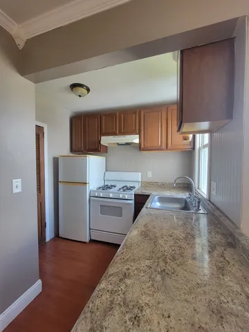a kitchen with a stove a refrigerator and a sink