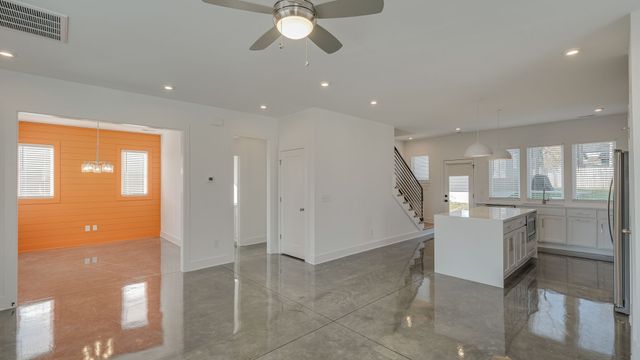 a kitchen with stainless steel appliances a sink a stove a microwave a refrigerator and cabinets