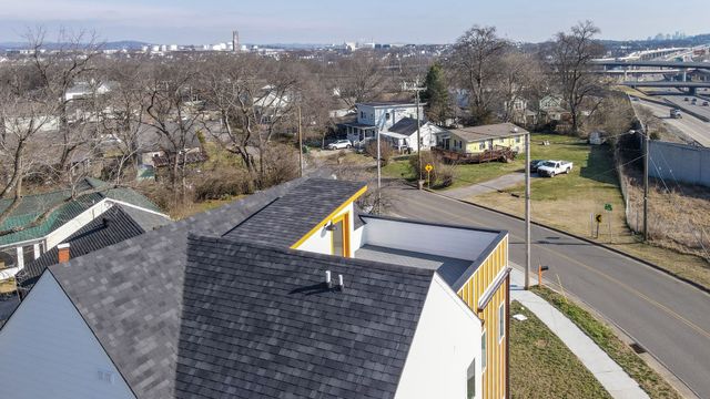 a view of a white house with a large space next to a yard