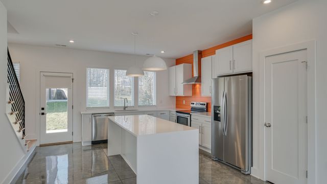 a view of a hallway with windows and chandelier