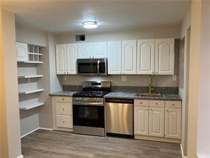 1148 Briarcliff Road Northeast, Unit 1 Atlanta, GA 30306 - Photo 5 of 33 a kitchen with stainless steel appliances granite countertop a stove a sink and a microwave