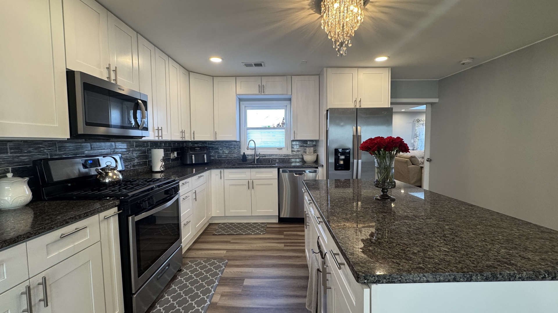 7700 West 83rd Street Bridgeview, IL 60455 - Photo 13 of 37 a kitchen with a sink dishwasher a stove a microwave oven and a dining table with wooden floor