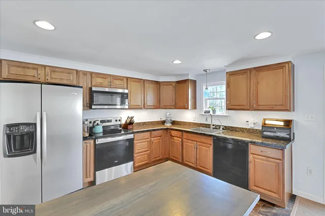 a kitchen with stainless steel appliances granite countertop a sink stove and refrigerator
