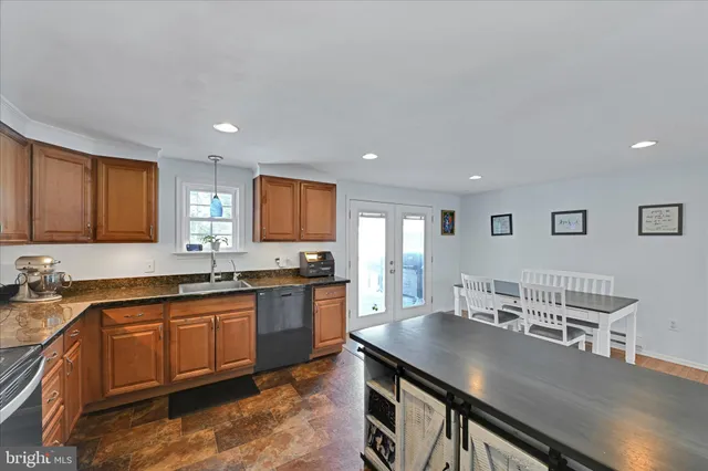 a kitchen with stainless steel appliances granite countertop a sink table and chairs