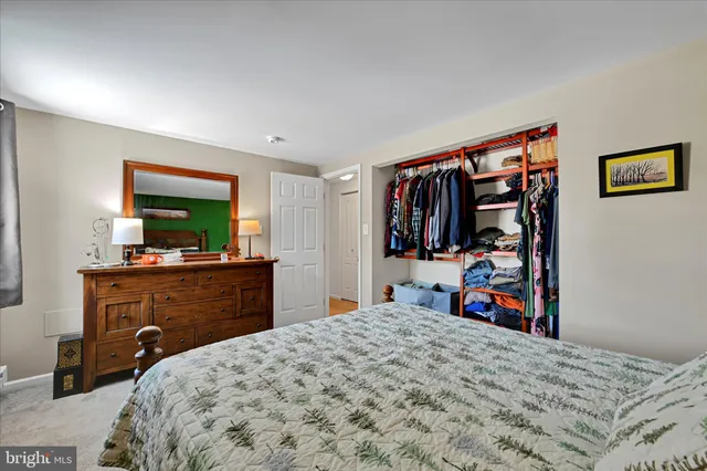 a bedroom with a bed and a flat tv screen on dresser
