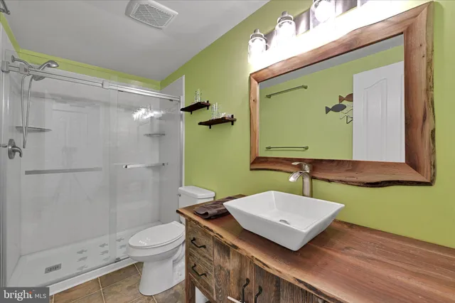 a bathroom with a toilet a sink and mirror