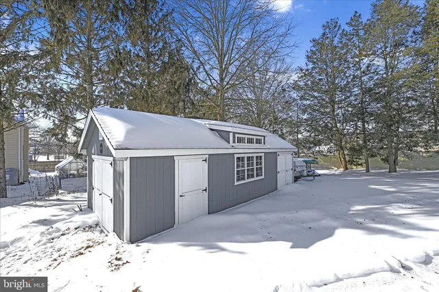 a view of a house with a yard covered in snow