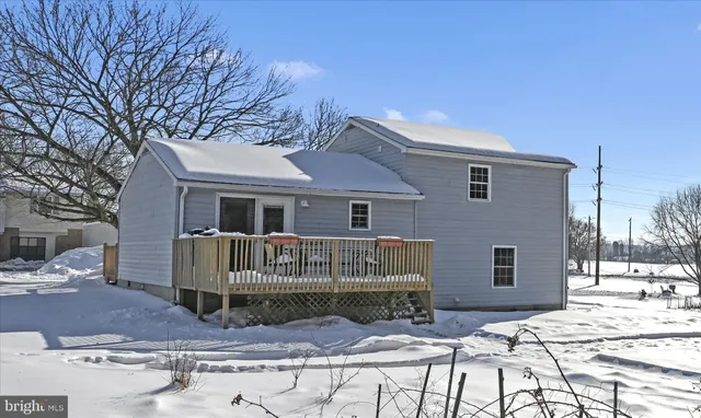 a view of a house with a bench in the backyard