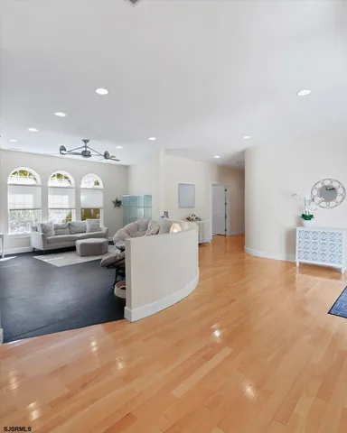 a bedroom with a bed window and a flat tv screen on dresser