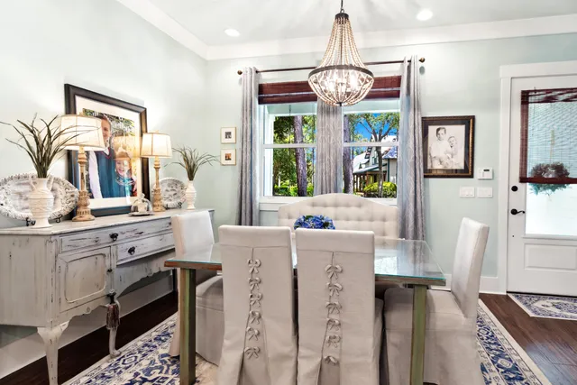 a dining room with furniture a chandelier and wooden floor