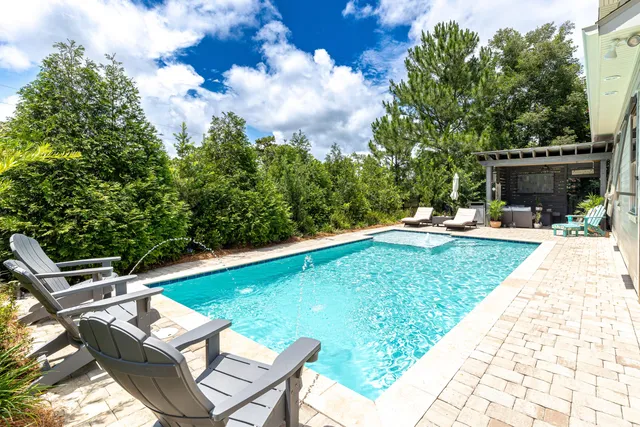 a view of house with backyard and sitting area