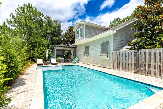 a view of a patio with table and chairs with wooden floor and fence