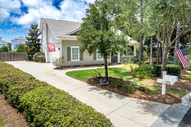 a front view of a house with a yard and potted plants