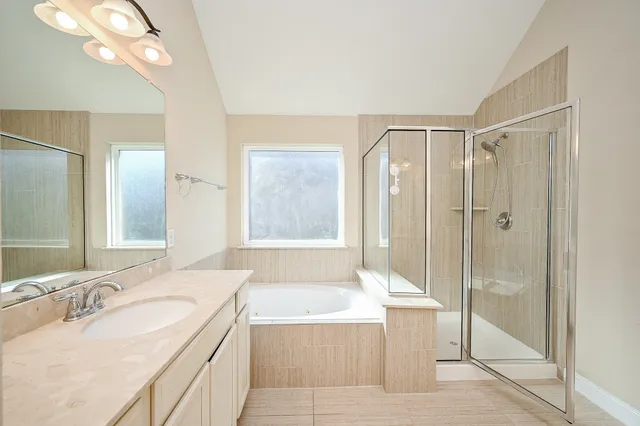 a bathroom with a tub sink shower and mirror