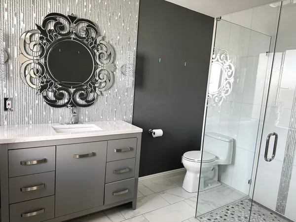 a bathroom with a granite countertop sink a toilet and shower