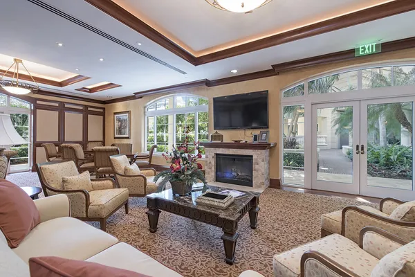 a living room with furniture a large window and gym equipment