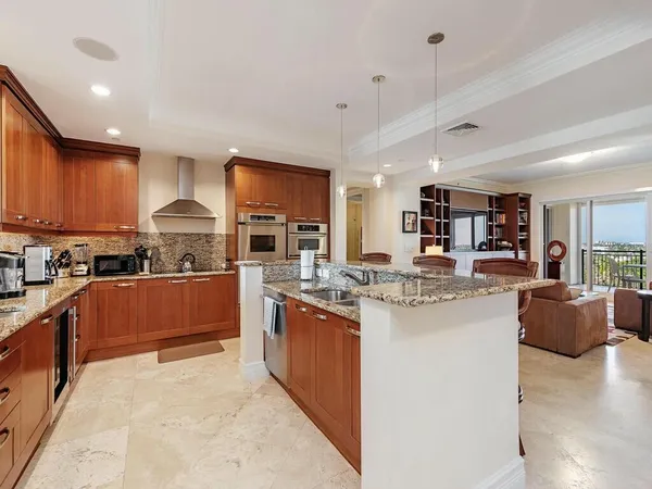 a kitchen with stainless steel appliances kitchen island granite countertop a stove and cabinets