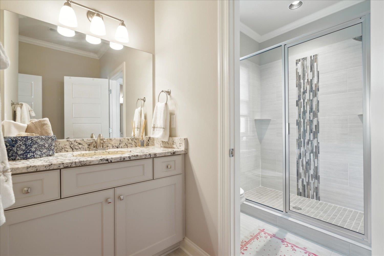 5140 Shady Grove Road Memphis, TN 38117 - Photo 28 of 39 a bathroom with a granite countertop sink a mirror and a shower