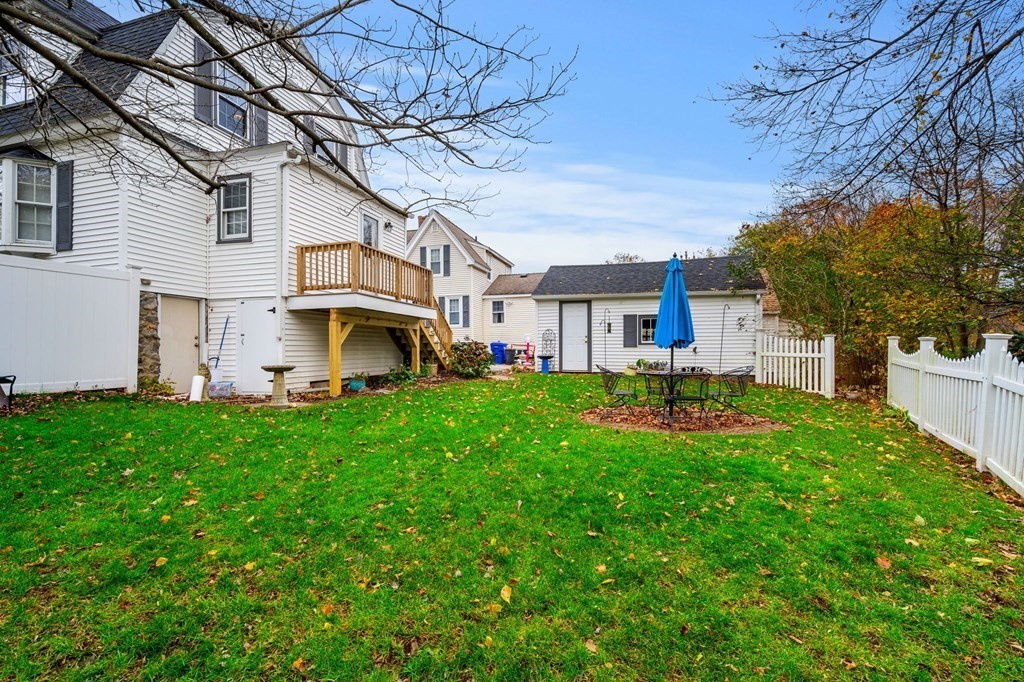 5 Harrison Street Maynard, MA 01754 - Photo 28 of 29 a view of a white house in front of a yard with potted plants and large trees
