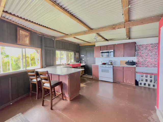 a kitchen with stainless steel appliances a table chairs refrigerator and cabinets