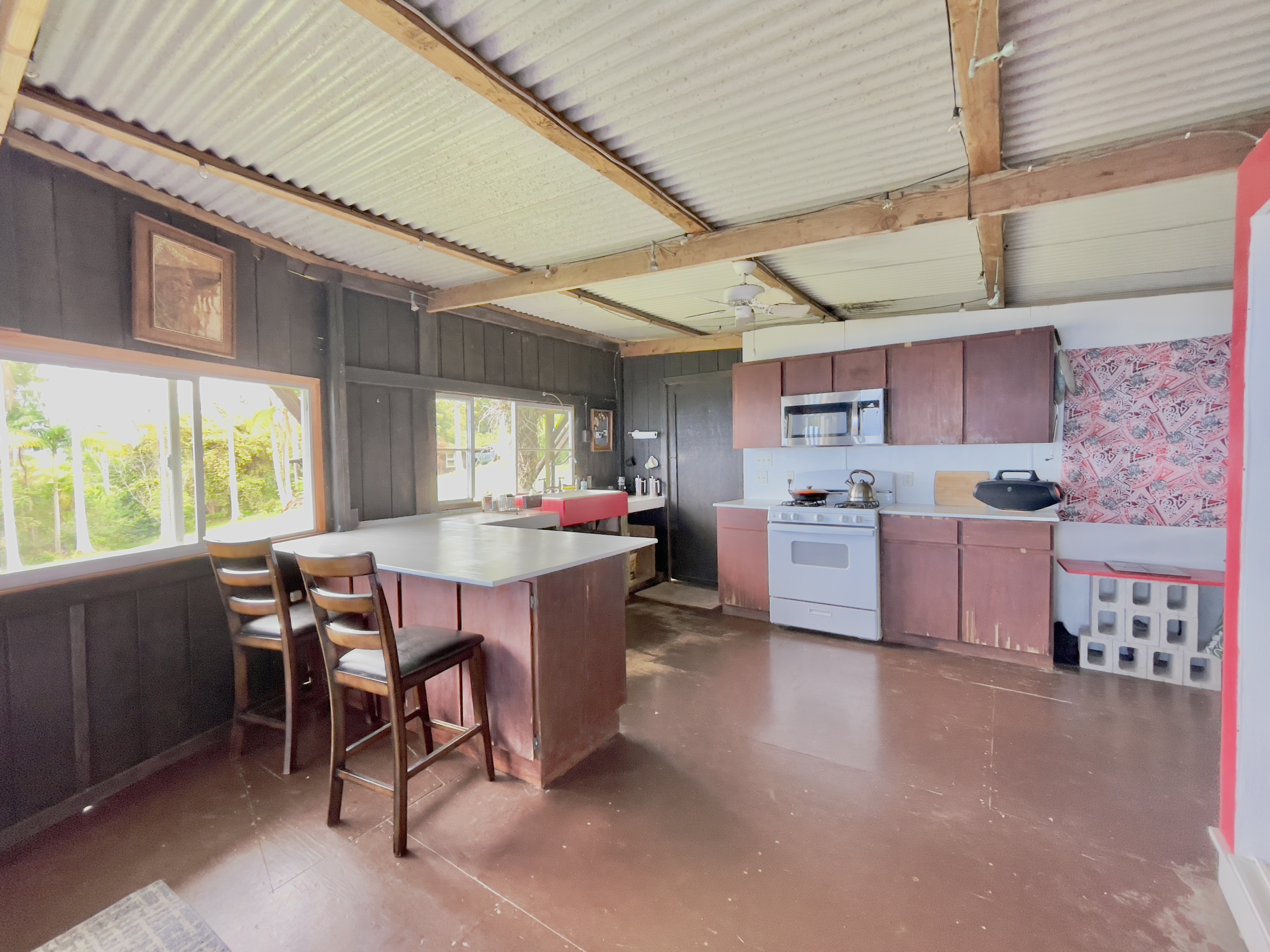 84-539 Telephone Exchange Road Captain Cook, HI 96704 - Photo 10 of 30 a kitchen with stainless steel appliances a table chairs refrigerator and cabinets