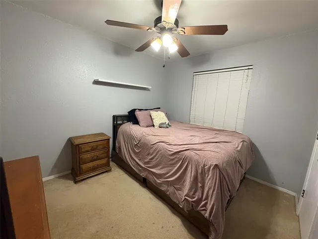 a bedroom with a bed and a ceiling fan