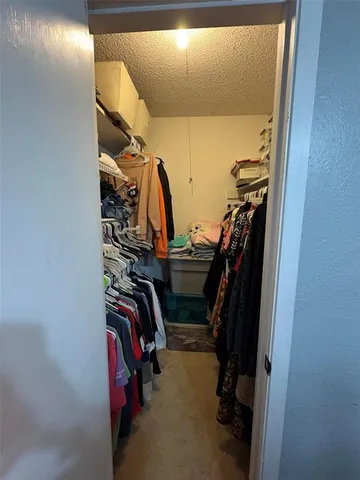 a view of walk in closet with clothes