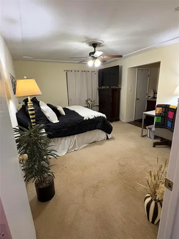 a bed room with a bed mirror and a chair