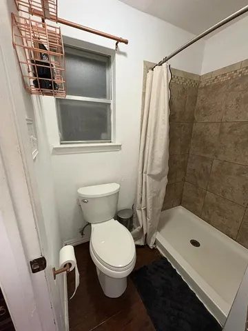 a bathroom with a toilet and a shower
