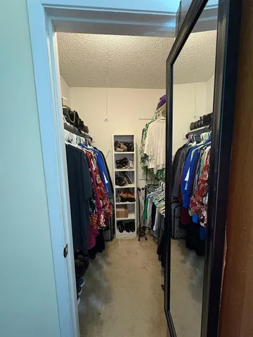 a view of walk in closet with clothes and shoes