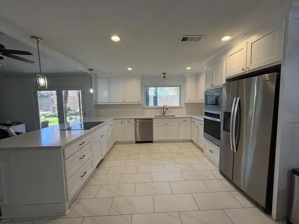 a large kitchen with cabinets and stainless steel appliances