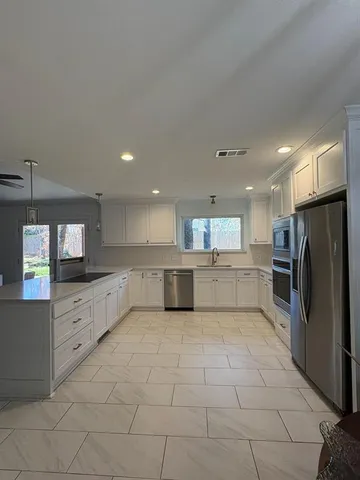 a large kitchen with a large counter top and stainless steel appliances