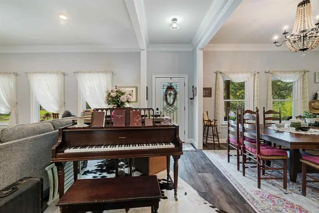 a living room with furniture a chandelier and a dining table