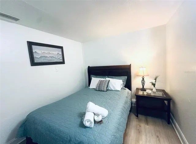 a bedroom with a bed and a painting on the wall