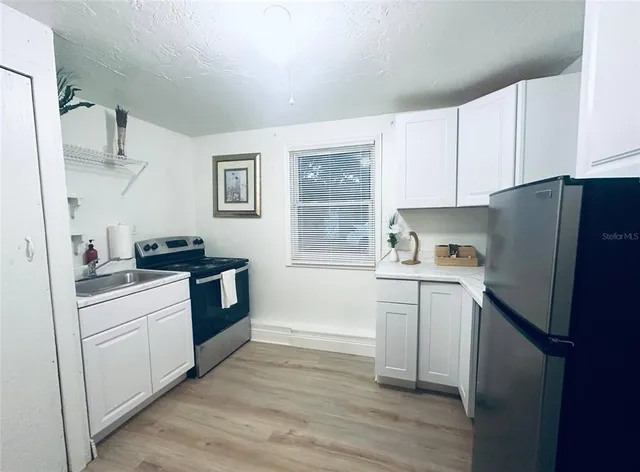 a kitchen with a refrigerator stove and sink