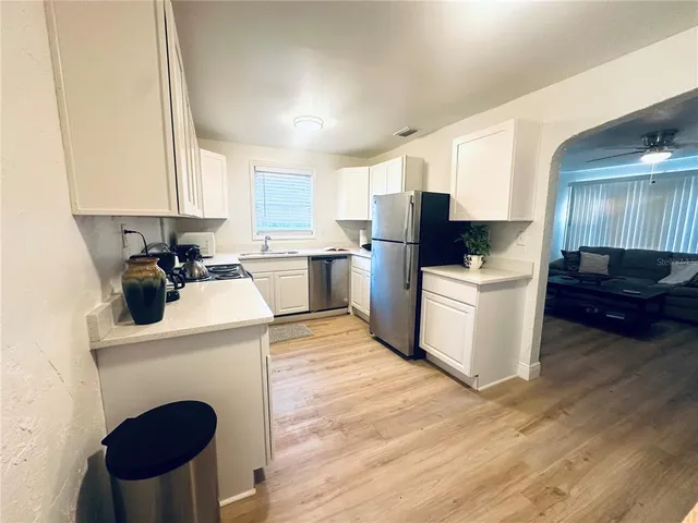 a kitchen with a sink a stove a refrigerator and cabinets