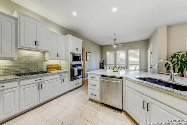 a kitchen with white cabinets and appliances