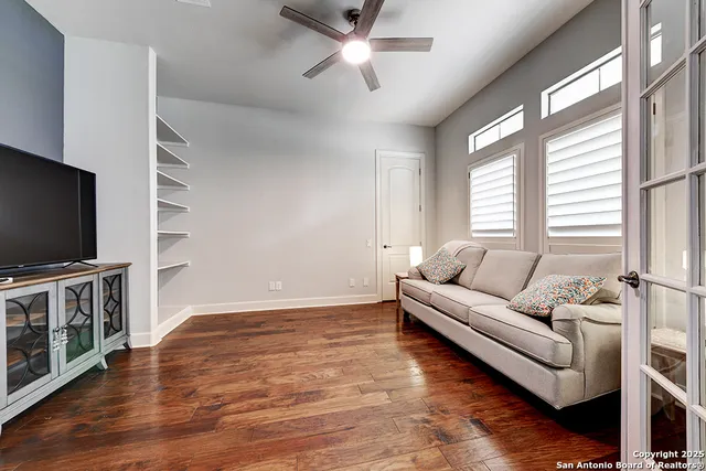 an empty room with wooden floor and windows
