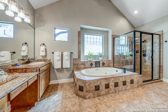 a large bathroom with a tub a sink shower and mirror