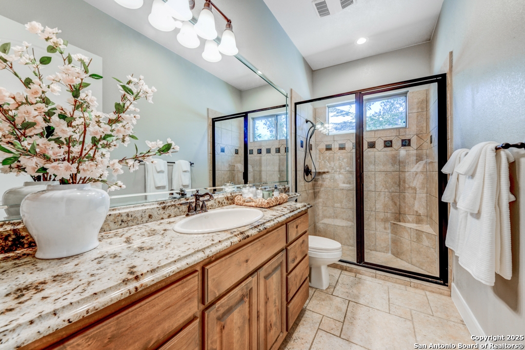 142 Candelaria Helotes, TX 78023 - Photo 31 of 53 a bathroom with a granite countertop sink a large mirror and a shower